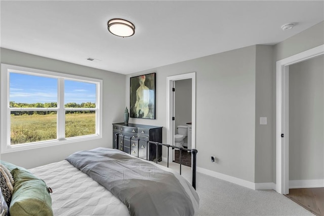 bedroom featuring light carpet and baseboards