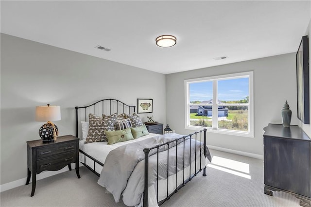 bedroom with visible vents, light carpet, and baseboards