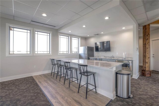 15459 W 171st Pl, Olathe, KS 66062 - kitchen with freestanding refrigerator, a kitchen breakfast bar, a peninsula, a sink, and wall oven