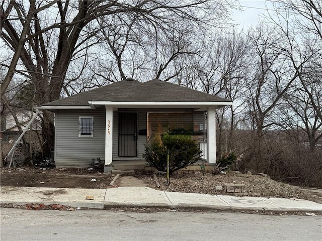 bungalow-style home featuring covered porch and a shingled roof