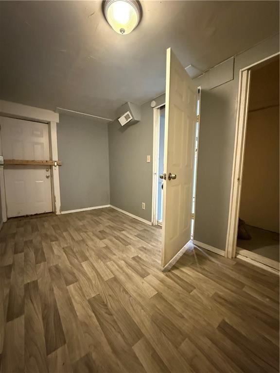 basement featuring baseboards and wood finished floors