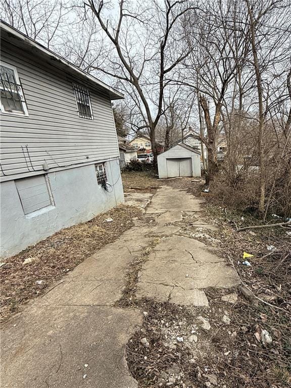 view of side of property with a detached garage and an outbuilding