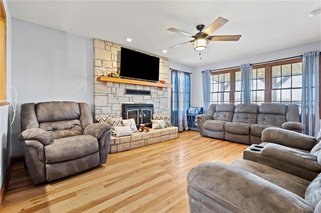 living area with a stone fireplace, recessed lighting, a ceiling fan, and wood finished floors