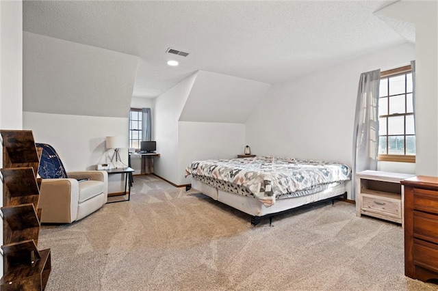 carpeted bedroom featuring vaulted ceiling, baseboards, visible vents, and a textured ceiling