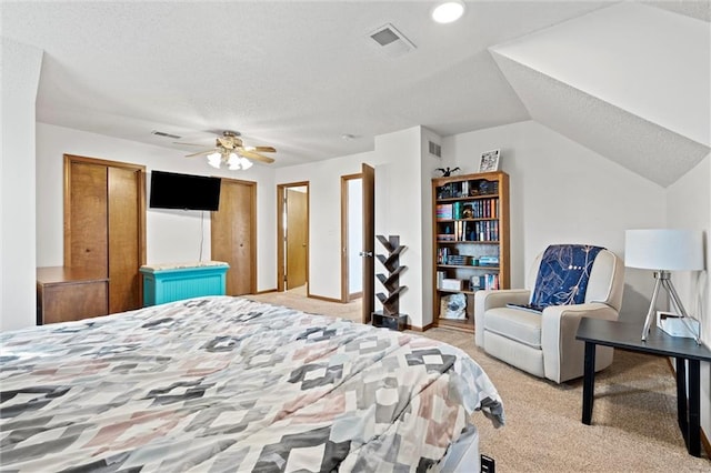 bedroom with visible vents, light colored carpet, and a textured ceiling