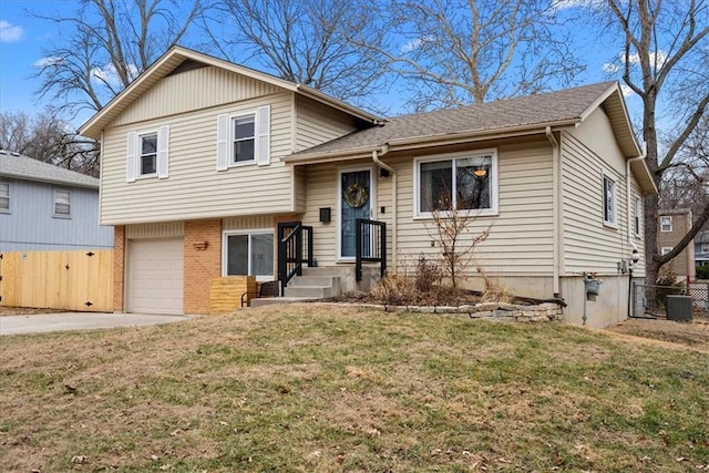 split level home with brick siding, fence, concrete driveway, a front yard, and a garage