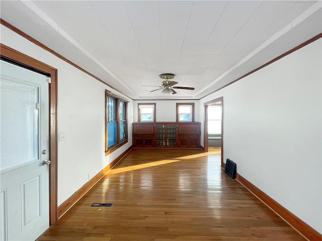 interior space featuring baseboards, ornamental molding, and dark wood finished floors