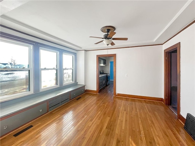 unfurnished room featuring crown molding, baseboards, visible vents, and light wood-style floors