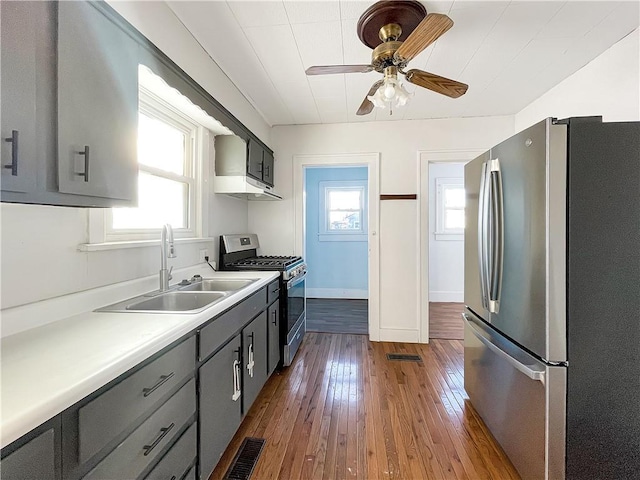 kitchen featuring a sink, stainless steel appliances, light countertops, and gray cabinetry