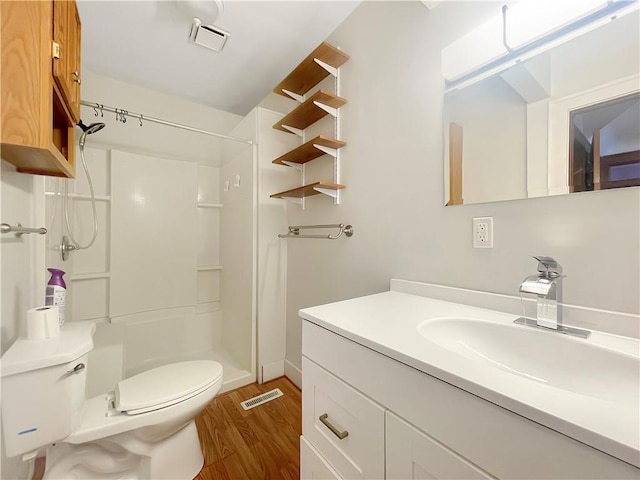 bathroom with toilet, a stall shower, visible vents, and wood finished floors