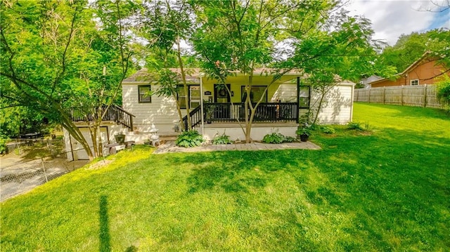 back of house with fence, a porch, and a lawn