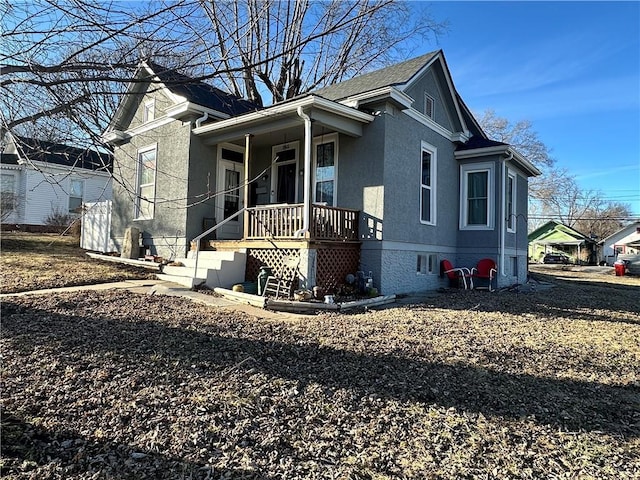 bungalow-style house with a porch and stucco siding