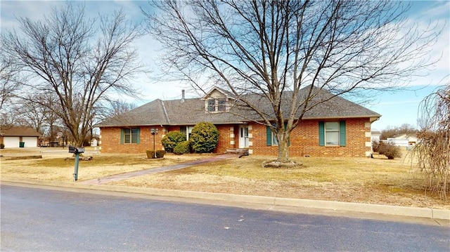 view of front of home featuring brick siding and a front yard