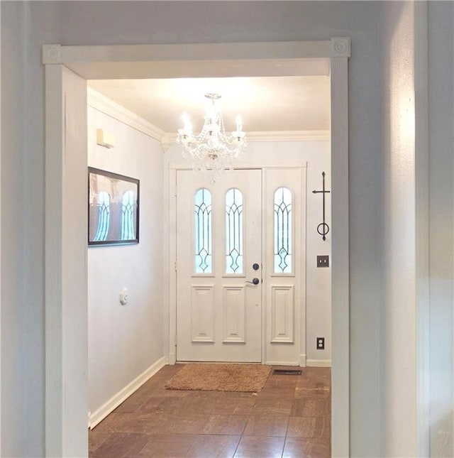 foyer featuring a chandelier, crown molding, and baseboards