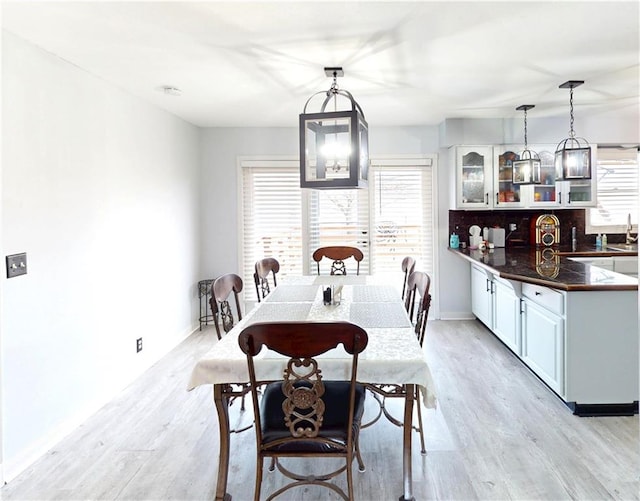 dining area with baseboards, a wealth of natural light, and light wood-style floors