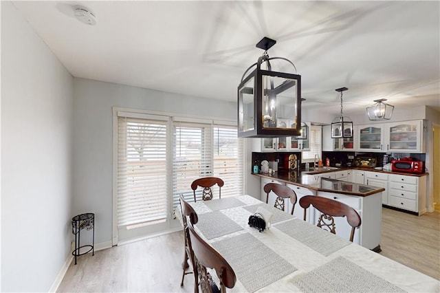 dining area featuring light wood finished floors and baseboards