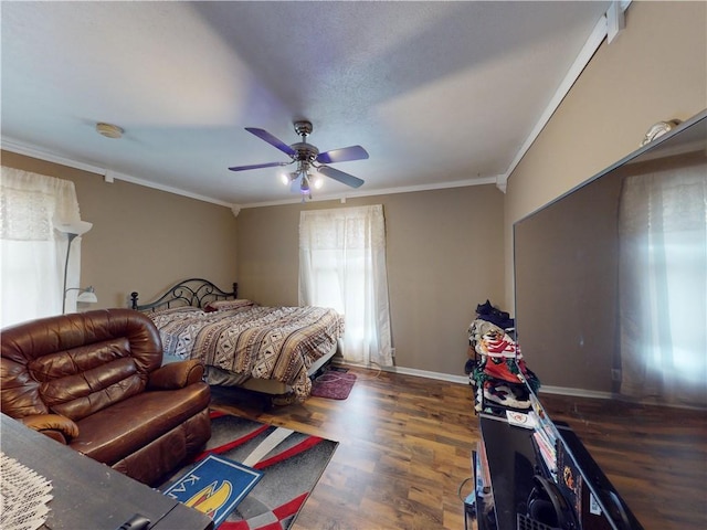 bedroom featuring ceiling fan, ornamental molding, wood finished floors, and baseboards