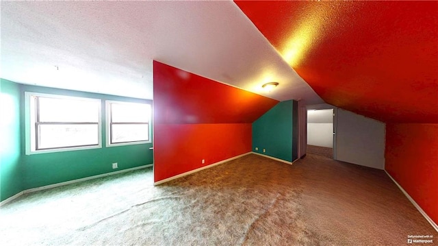 bonus room featuring a textured ceiling, vaulted ceiling, carpet, and baseboards