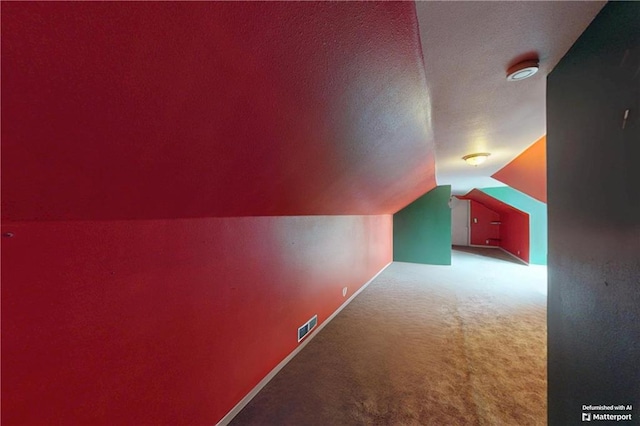 additional living space featuring carpet, visible vents, vaulted ceiling, a textured ceiling, and baseboards