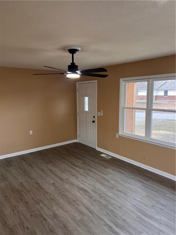 foyer entrance featuring dark wood-style floors, visible vents, ceiling fan, and baseboards