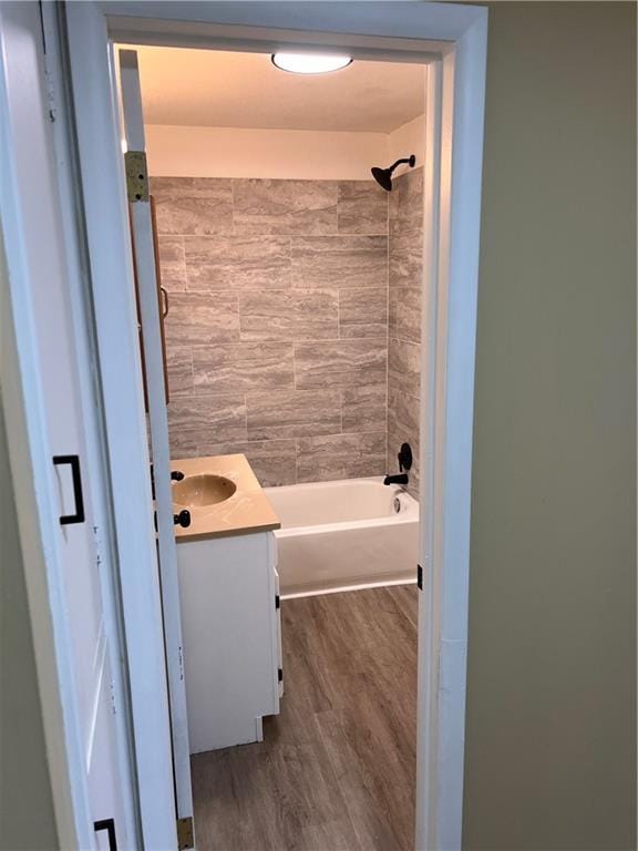 full bath with  shower combination, vanity, and wood finished floors