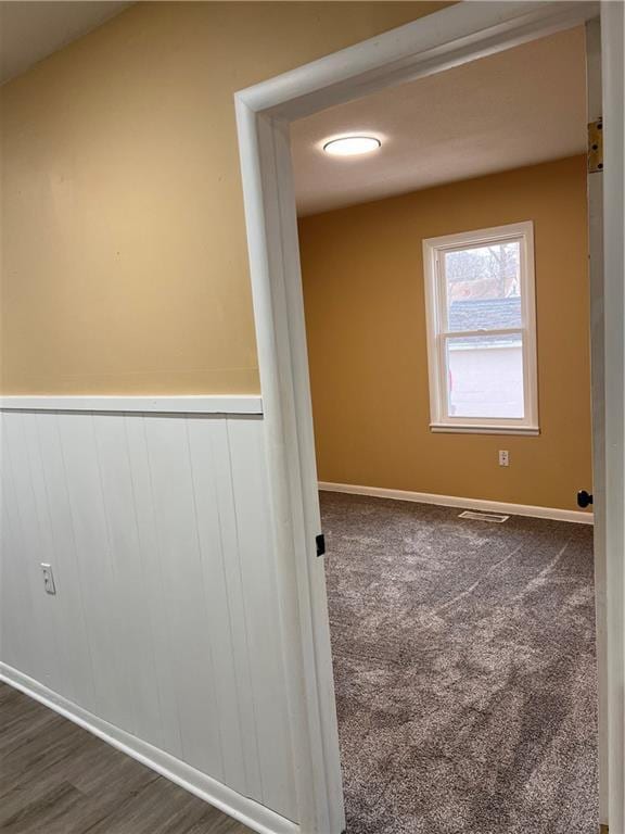 empty room featuring dark colored carpet and visible vents