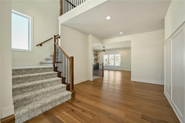 stairs featuring baseboards, hardwood / wood-style floors, and recessed lighting