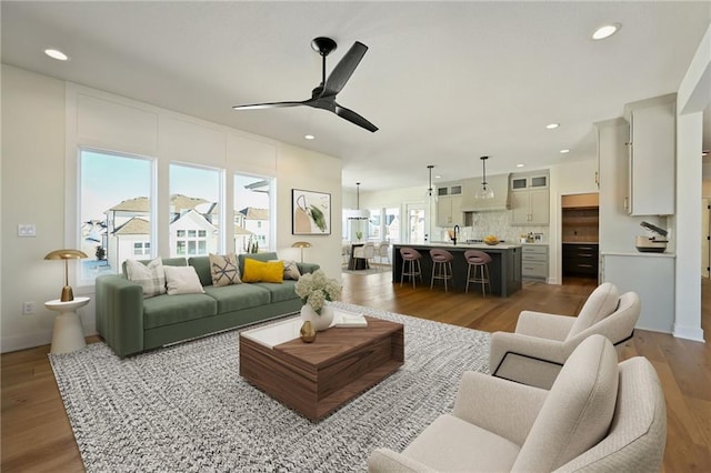 living room featuring ceiling fan, dark wood-style flooring, baseboards, and recessed lighting