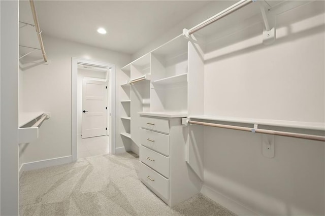 walk in closet with light colored carpet