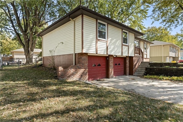 view of property exterior with driveway, an attached garage, fence, a yard, and brick siding