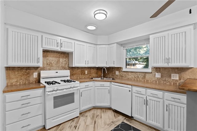 kitchen featuring white appliances, white cabinetry, a sink, and backsplash