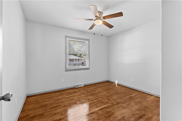 unfurnished room featuring a ceiling fan, visible vents, and wood finished floors