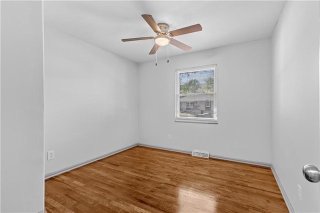 empty room with ceiling fan, visible vents, and wood finished floors