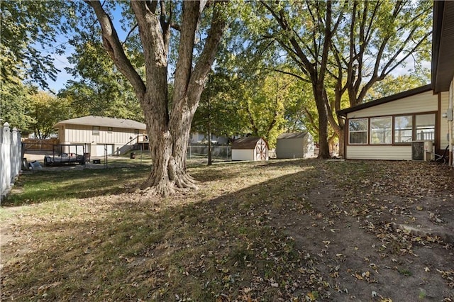 view of yard featuring an outbuilding, fence, and a storage shed