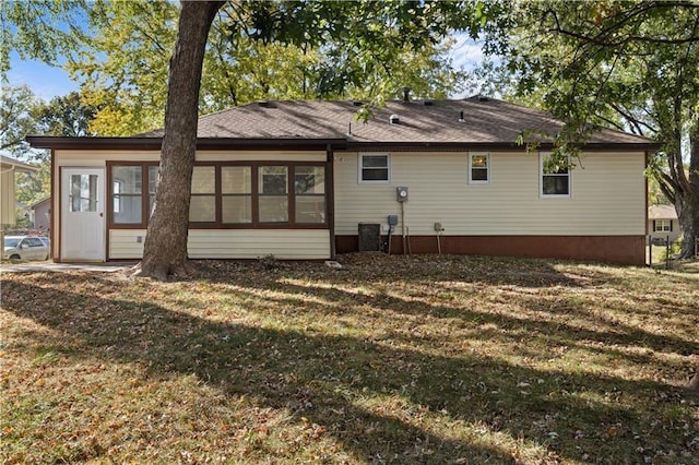 back of property featuring cooling unit and a lawn