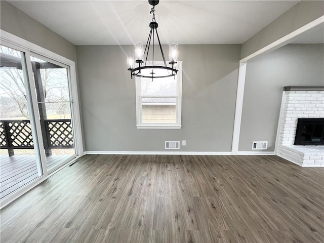 unfurnished dining area featuring visible vents, plenty of natural light, and wood finished floors