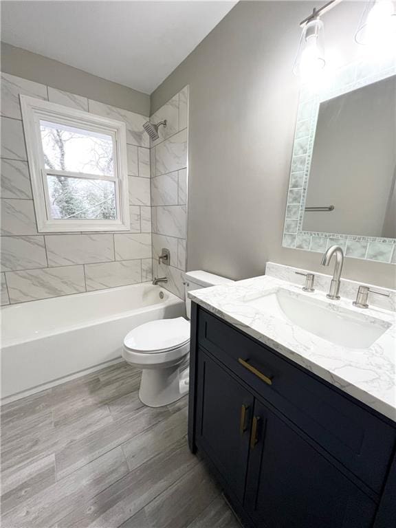 full bathroom with toilet, vanity, wood finished floors, and shower / bathtub combination