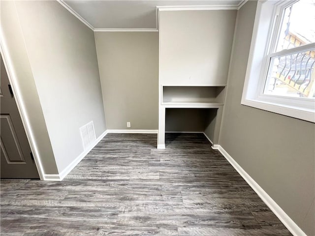 interior space with ornamental molding, visible vents, dark wood-type flooring, and baseboards