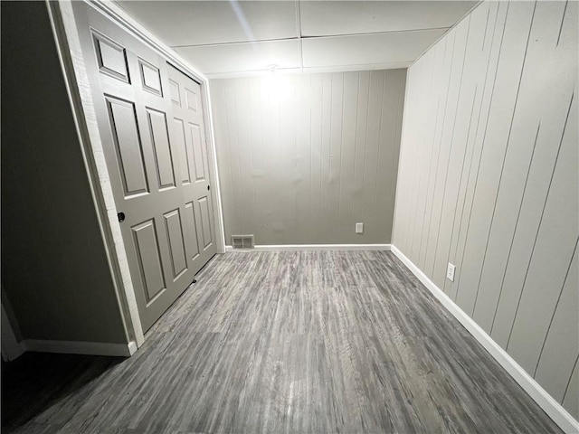 spare room featuring visible vents, baseboards, and dark wood-style flooring