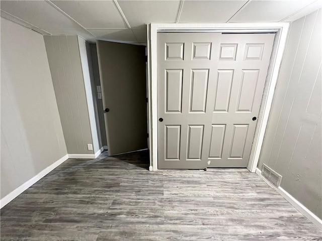 unfurnished bedroom featuring baseboards, a closet, visible vents, and wood finished floors