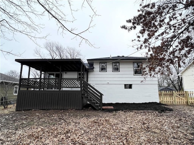 rear view of property with stairs and fence