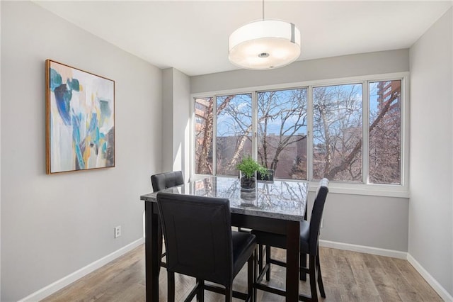 dining room with light wood-style floors and baseboards