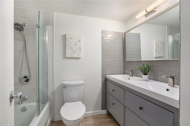 bathroom featuring wood finished floors, a sink, toilet, and tasteful backsplash