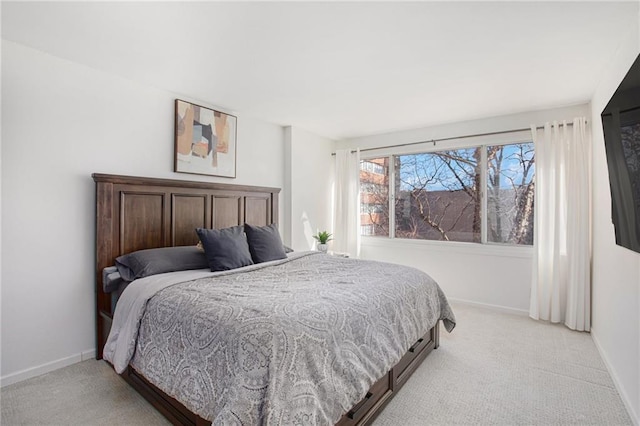 bedroom with light carpet and baseboards