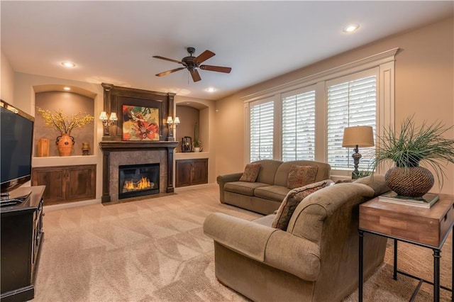 living area with a fireplace with flush hearth, light colored carpet, recessed lighting, and ceiling fan