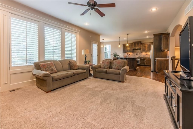 living room featuring arched walkways, visible vents, and recessed lighting