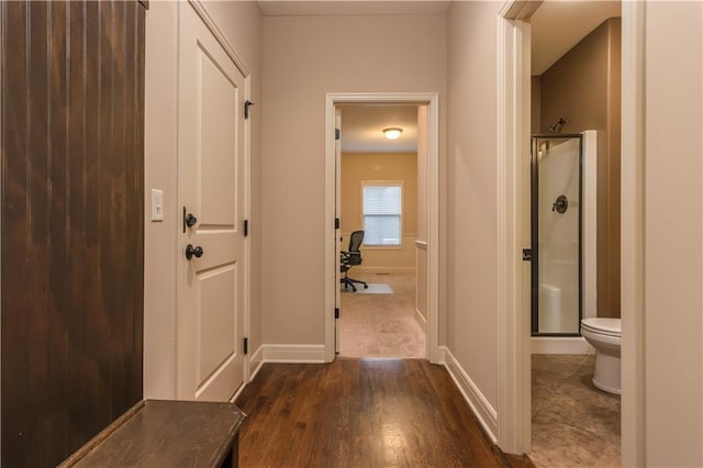 hall featuring baseboards and dark wood-style flooring