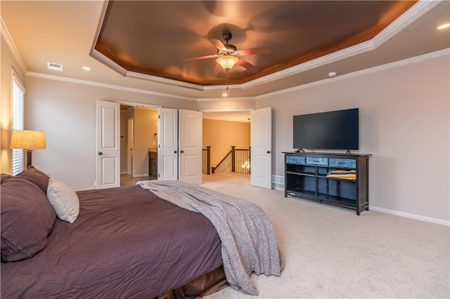 bedroom with visible vents, light carpet, a tray ceiling, crown molding, and baseboards