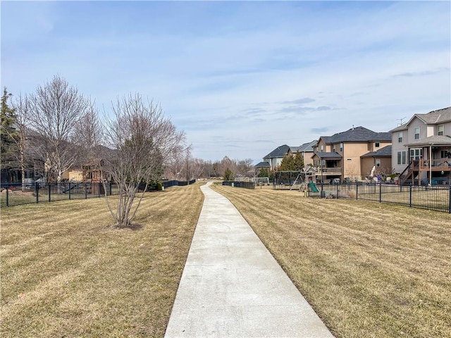 surrounding community with a residential view, a lawn, playground community, and fence