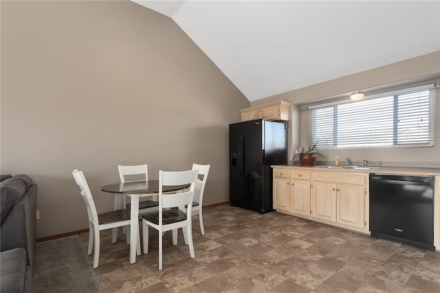 kitchen featuring light brown cabinets, baseboards, light countertops, vaulted ceiling, and black appliances